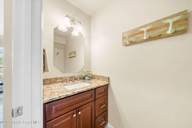 a bathroom with a granite countertop sink and a mirror