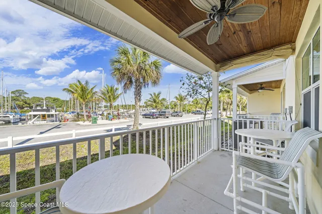 a view of a balcony with dining table and chairs