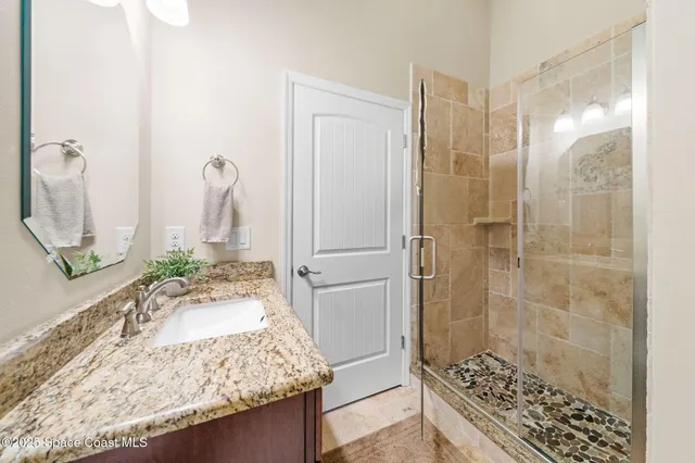 a bathroom with a granite countertop toilet sink and mirror