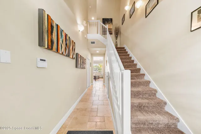 a view of staircase with lots of frames on wall and a window