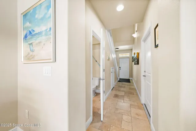 a view of a hallway with wooden floor and closet