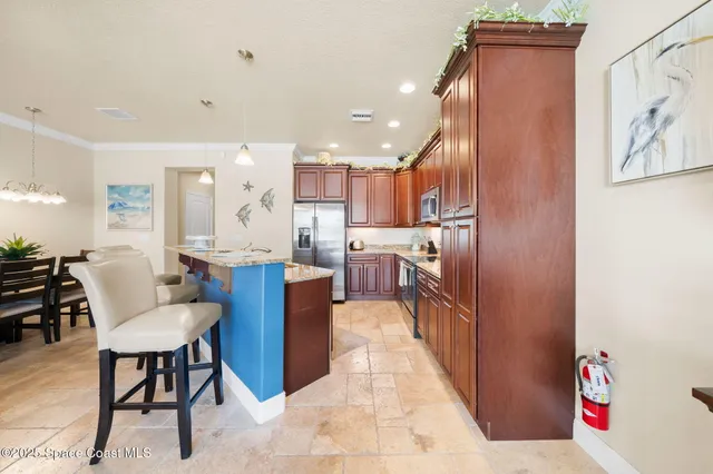 a living room with stainless steel appliances kitchen island granite countertop furniture and a refrigerator