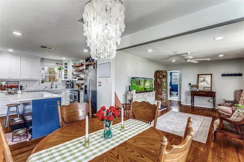 a living room with furniture a chandelier and kitchen view