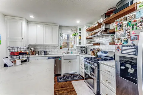 a kitchen with stainless steel appliances granite countertop a stove and cabinets