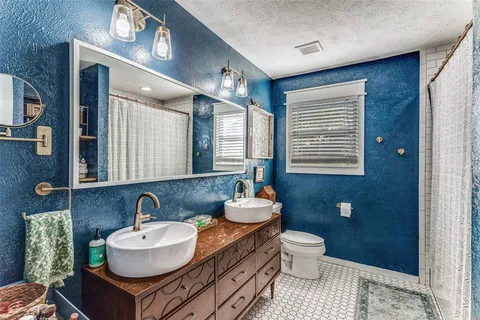 a bathroom with a sink a toilet and a mirror