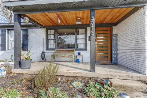 a view of a porch with a table and chairs and potted plants