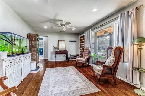 a living room with furniture a flat screen tv and a large window