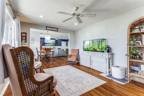 a living room with furniture a flat screen tv and a table
