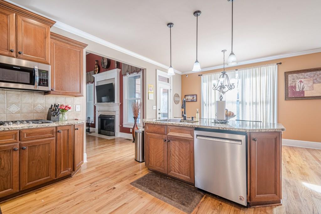 1765 Dew Place Southwest Marietta, GA 30064 - Photo 13 of 61 a kitchen with kitchen island granite countertop wooden floors and stainless steel appliances