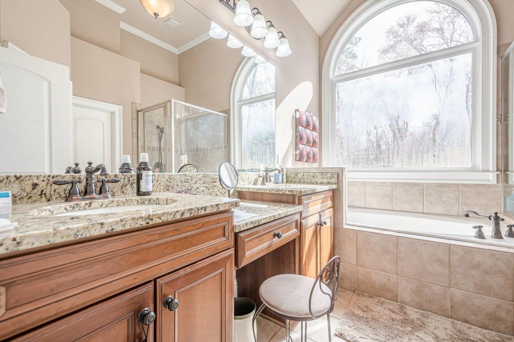 1765 Dew Place Southwest Marietta, GA 30064 - Photo 31 of 61 a bathroom with a granite countertop bathtub a sink and a large mirror