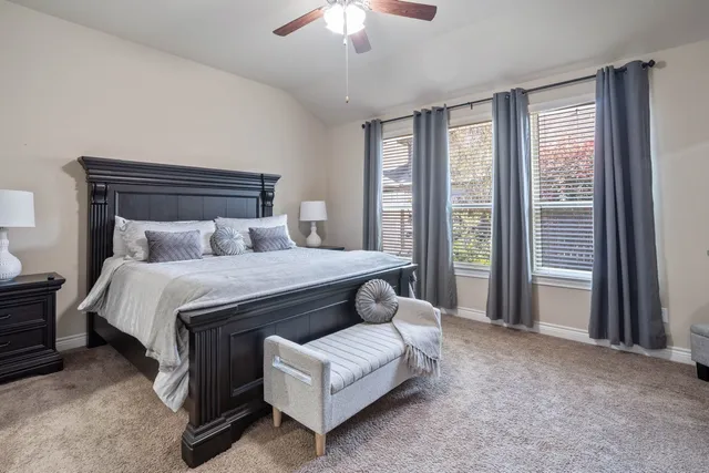 a spacious bedroom with a bed and a chandelier