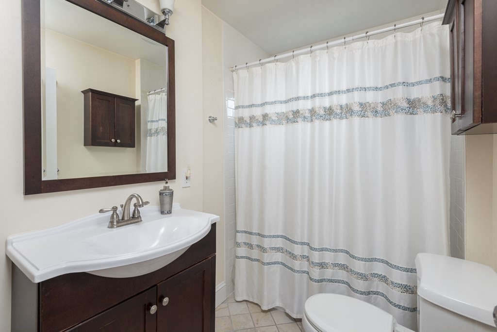 39 Edgemont Road Braintree, MA 02184 - Photo 24 of 39 a bathroom with a sink toilet a mirror and shower curtain