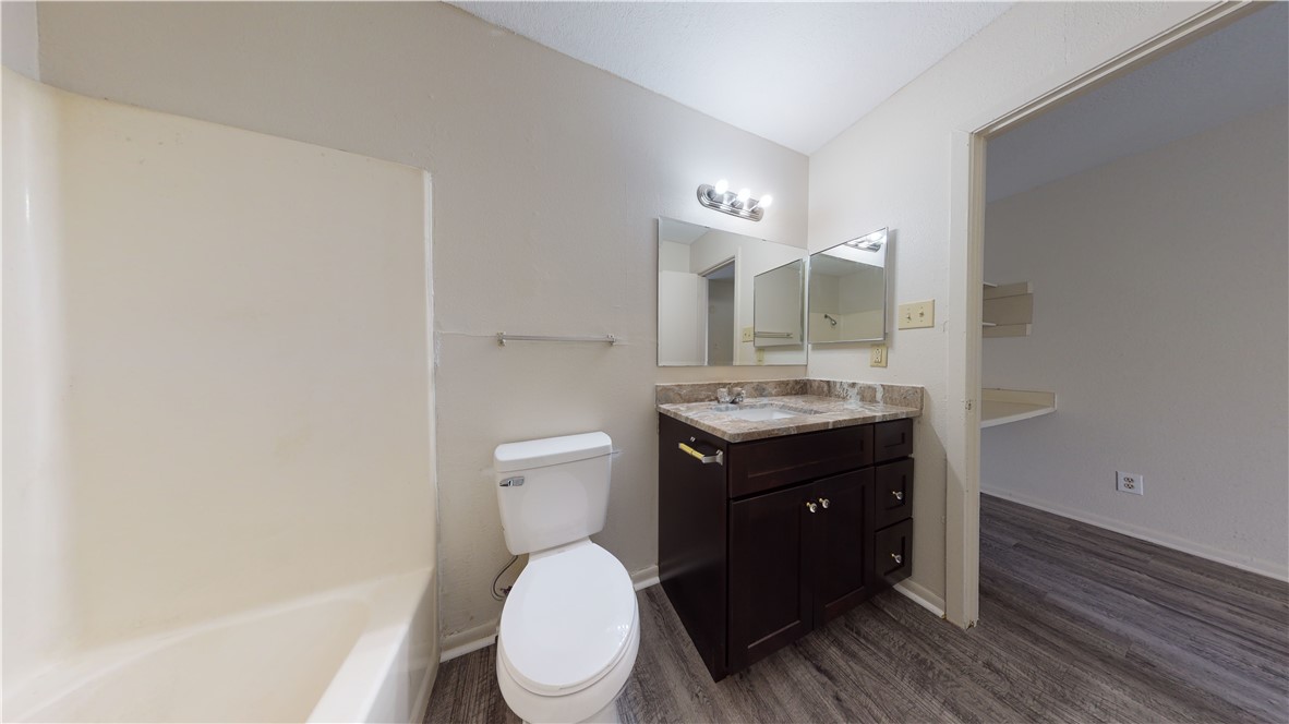 725 Peppertree Drive, Unit 23 Bryan, TX 77801 - Photo 11 of 16 Bathroom featuring dark wood-type flooring, vanity, and shower / washtub combination