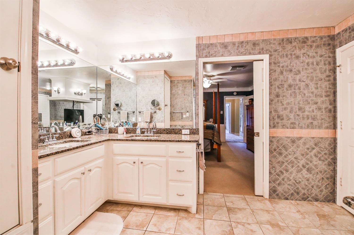 3204 55th Street Lubbock, TX 79413 - Photo 24 of 41 a bathroom with a granite countertop sink a mirror and a shower
