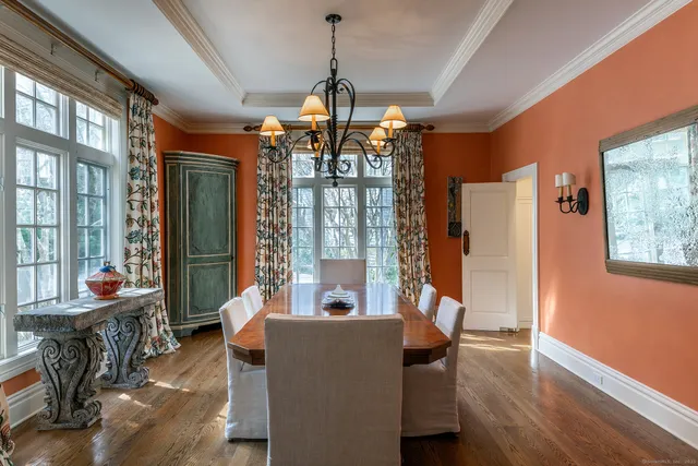 a dining room with furniture large windows and wooden floor
