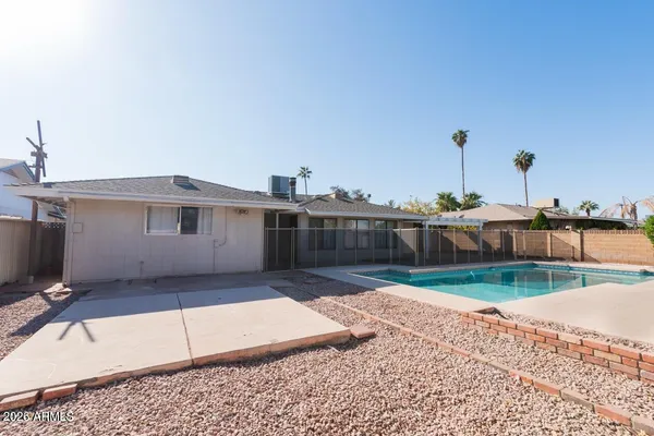 a view of a house with backyard and a tree