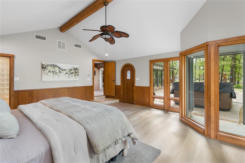 692 Private Road 5937 Emory, TX 75440 - Photo 25 of 40 a spacious bedroom with a large bed and a chandelier