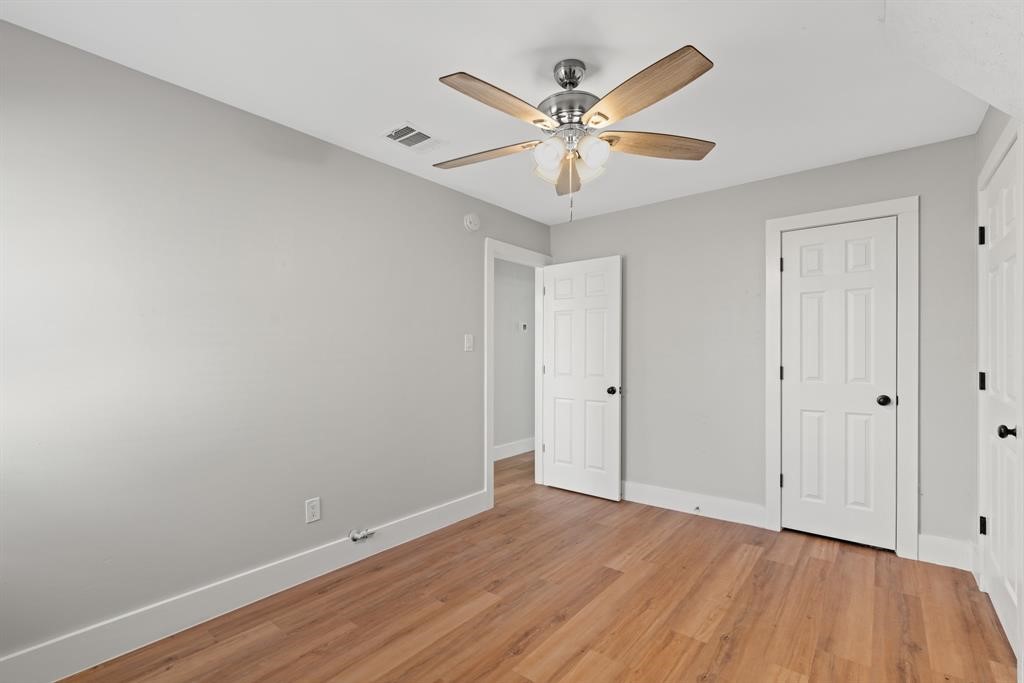 915 Avenue East Rosenberg, TX 77471 - Photo 15 of 18 a view of a room with wooden floor and a ceiling fan