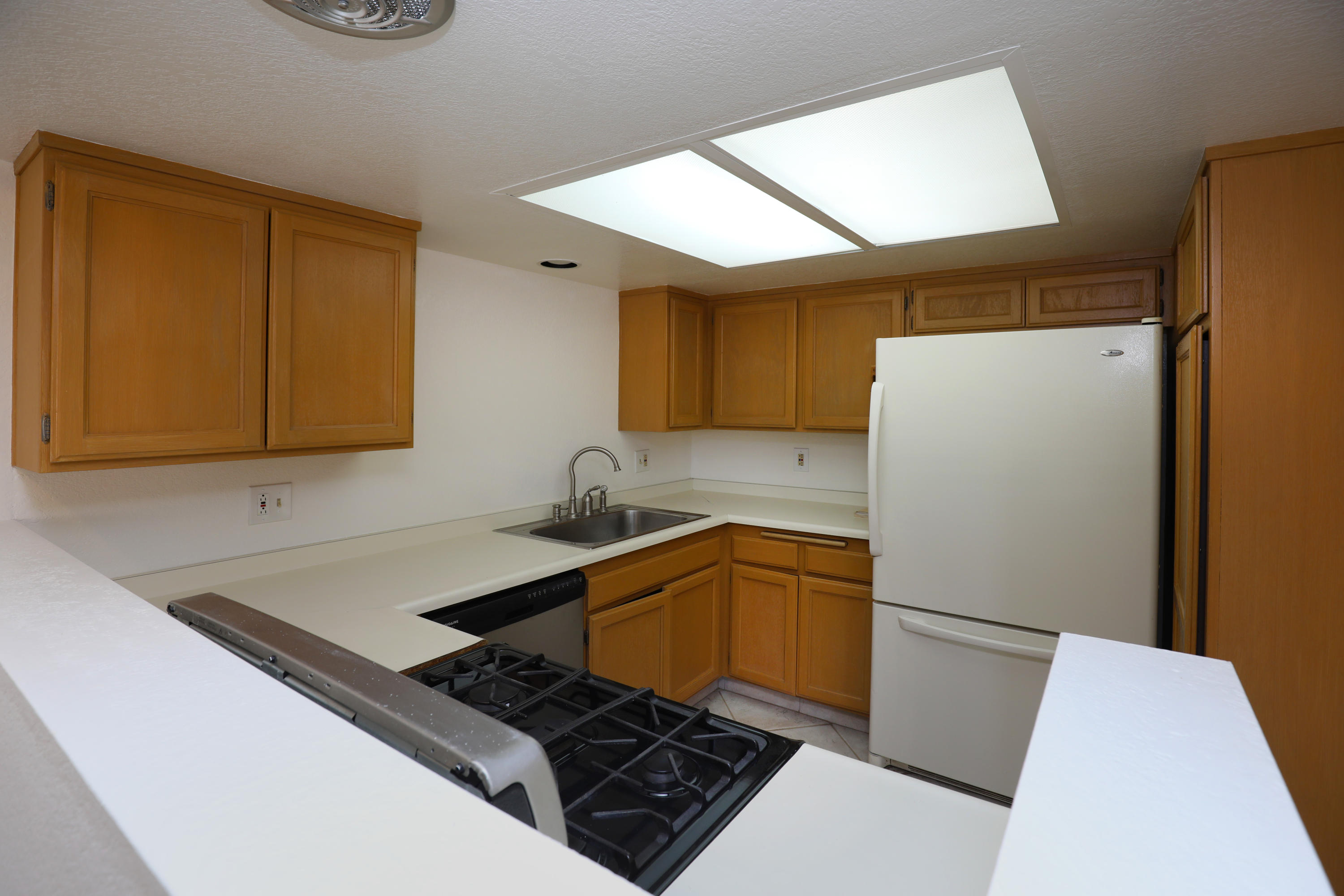 315 Pacific Oaks Road Goleta, CA 93117 - Photo 10 of 20 a kitchen with a sink a refrigerator and a stove top oven