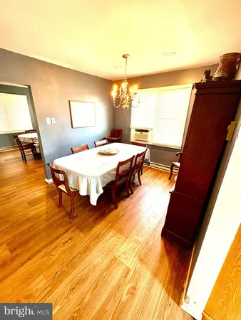 a living room with table chairs and a wooden floor
