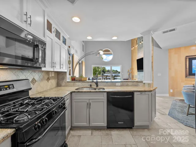 a kitchen with stainless steel appliances a sink stove and cabinets
