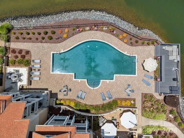 an aerial view of a house with swimming pool and outdoor seating