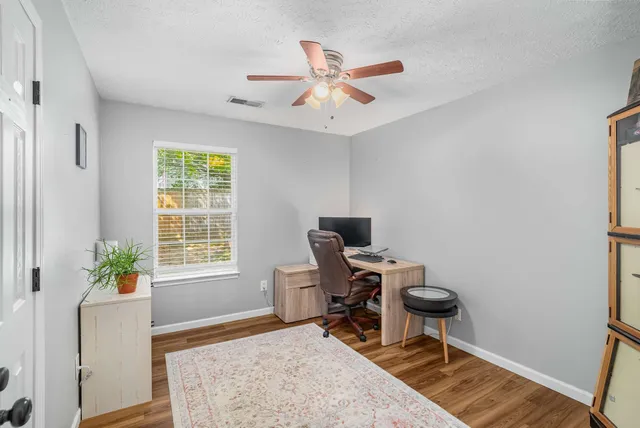 a workspace with wooden floor and a window