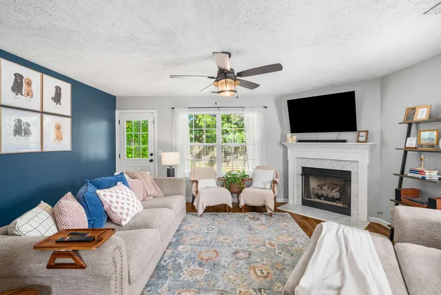 a living room with furniture a fireplace and a flat screen tv