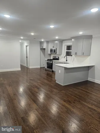a view of kitchen with wooden floor and electronic appliances