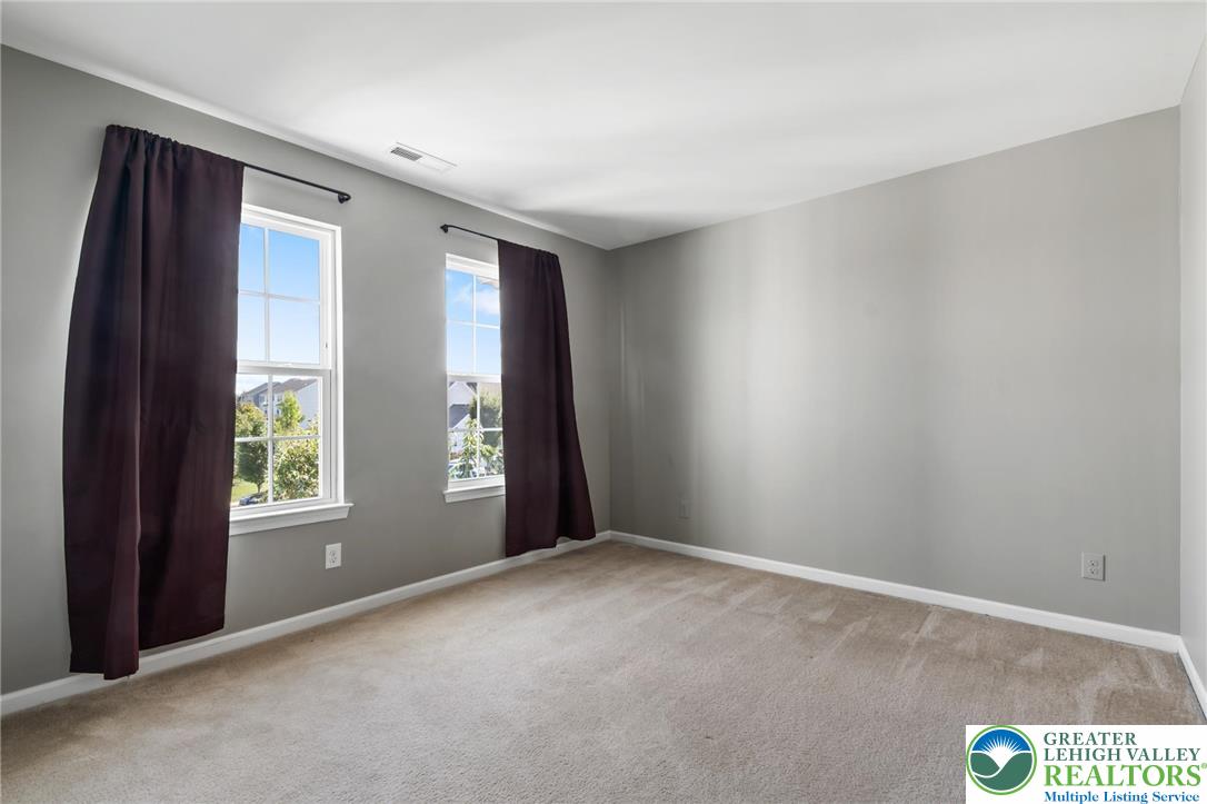 8455 Starling Road Breinigsville, PA 18031 - Photo 17 of 24 Ample natural light illuminates this generously proportioned bed room, offering a neutral canvas for personalization.