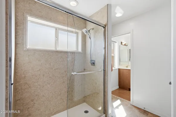 a bathroom with a glass shower door and a mirror