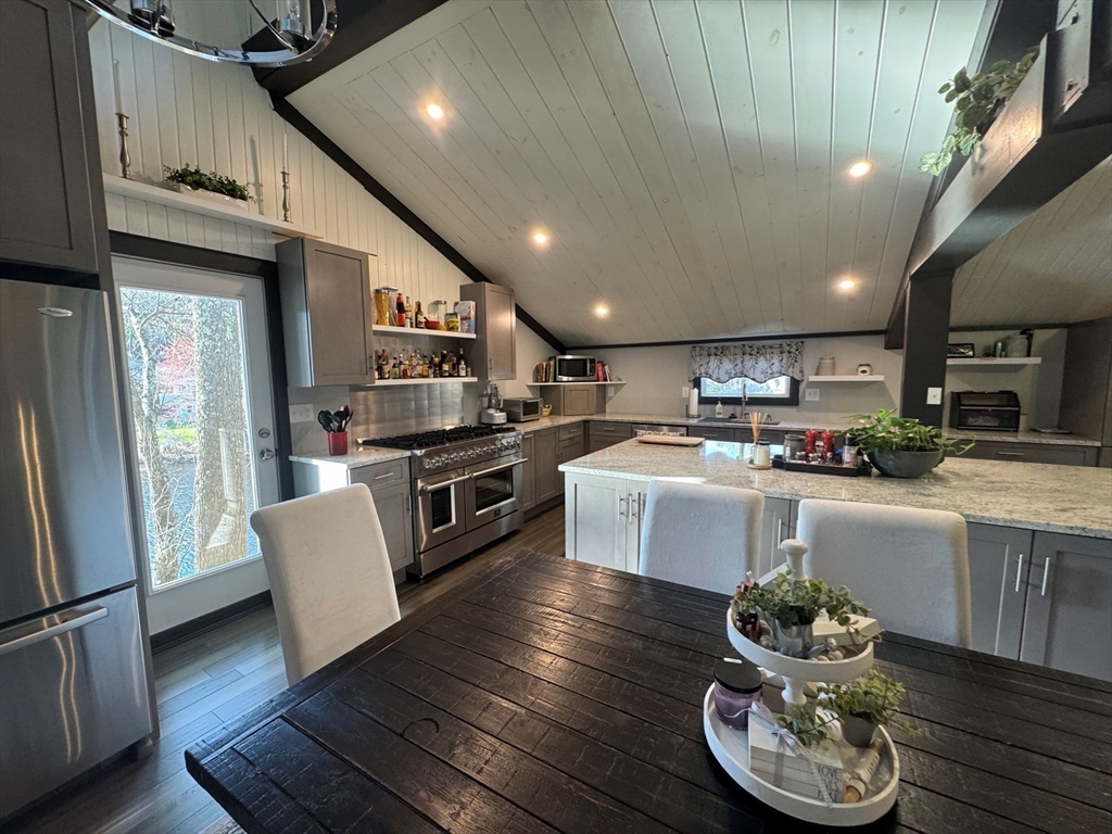 153 Off Pond Street Dunstable, MA 01827 - Photo 8 of 35 a kitchen with stainless steel appliances wooden floor dining table and chairs