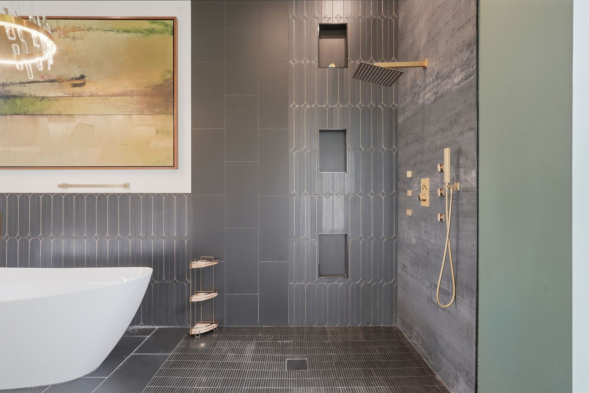 2743 Bobville Road Montgomery, TX 77316 - Photo 32 of 50 This bathroom features a modern design with sleek dark tiles, a luxurious rainfall showerhead, and built-in shelving. It also includes a stylish freestanding bathtub and contemporary artwork, creating a sophisticated and relaxing atmosphere.
