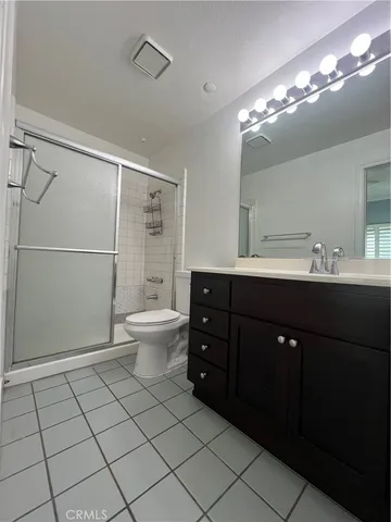 a spacious bathroom with a double vanity sink toilet and a mirror