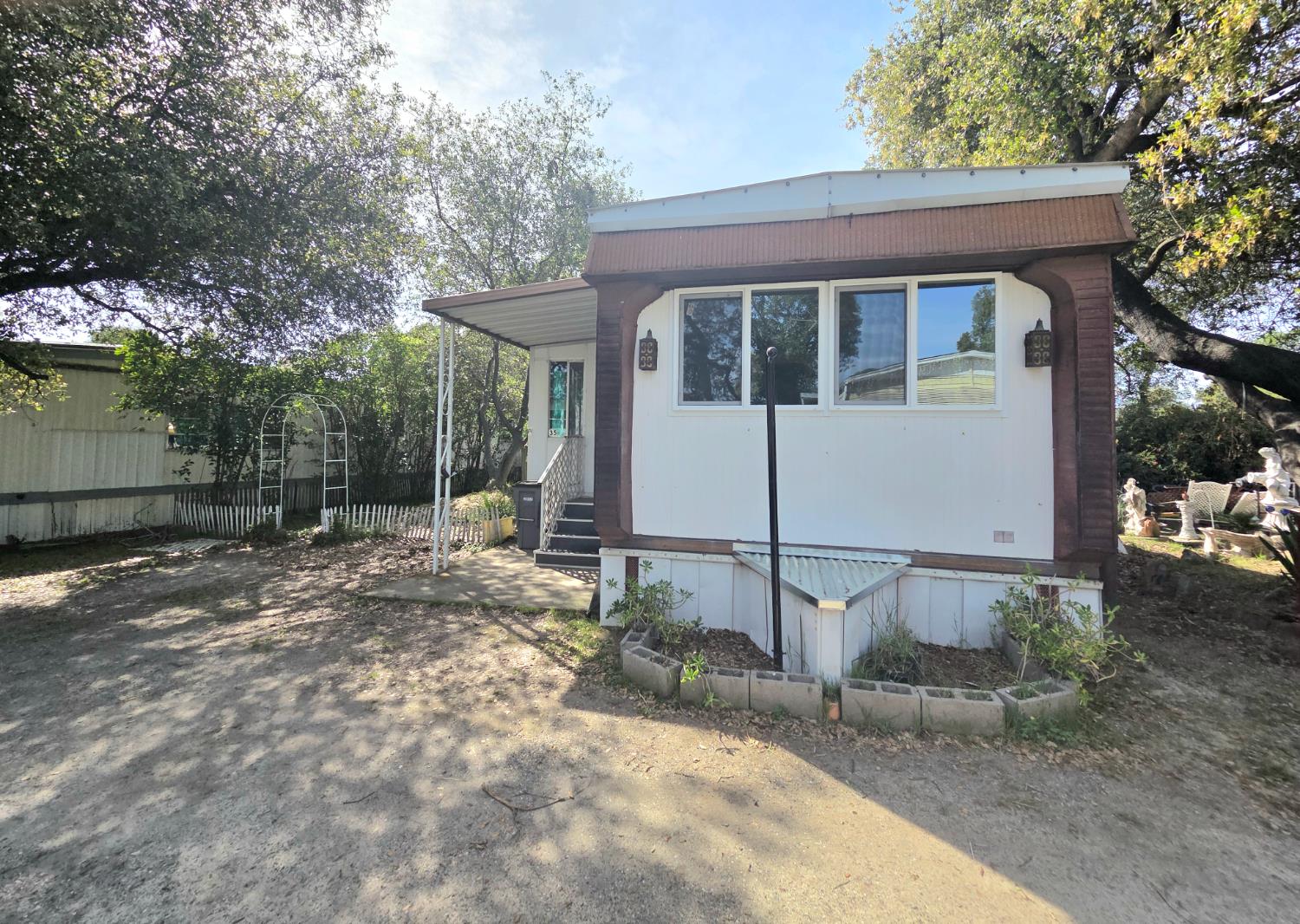 a view of a white house with large trees and outdoor space