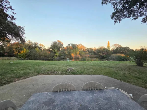 a backyard of a house with lots of green space and lake view
