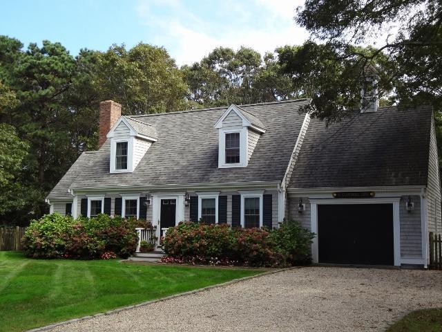 61 Clamshell Cove Road Cotuit, MA 02635 - Photo 1 of 12 a front view of a house with a yard and garage