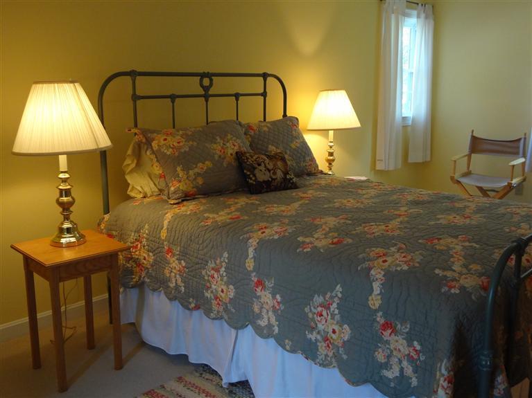 61 Clamshell Cove Road Cotuit, MA 02635 - Photo 6 of 12 a bedroom with a bed and a lamp