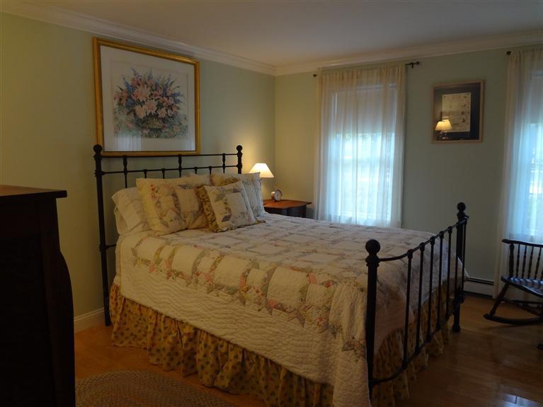 61 Clamshell Cove Road Cotuit, MA 02635 - Photo 7 of 12 a bedroom with a bed and a painting on the wall