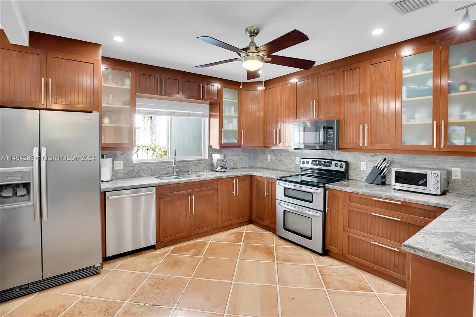4331 Alton Road Miami Beach, FL 33140 - Photo 5 of 33 a kitchen with stainless steel appliances granite countertop a stove sink and refrigerator