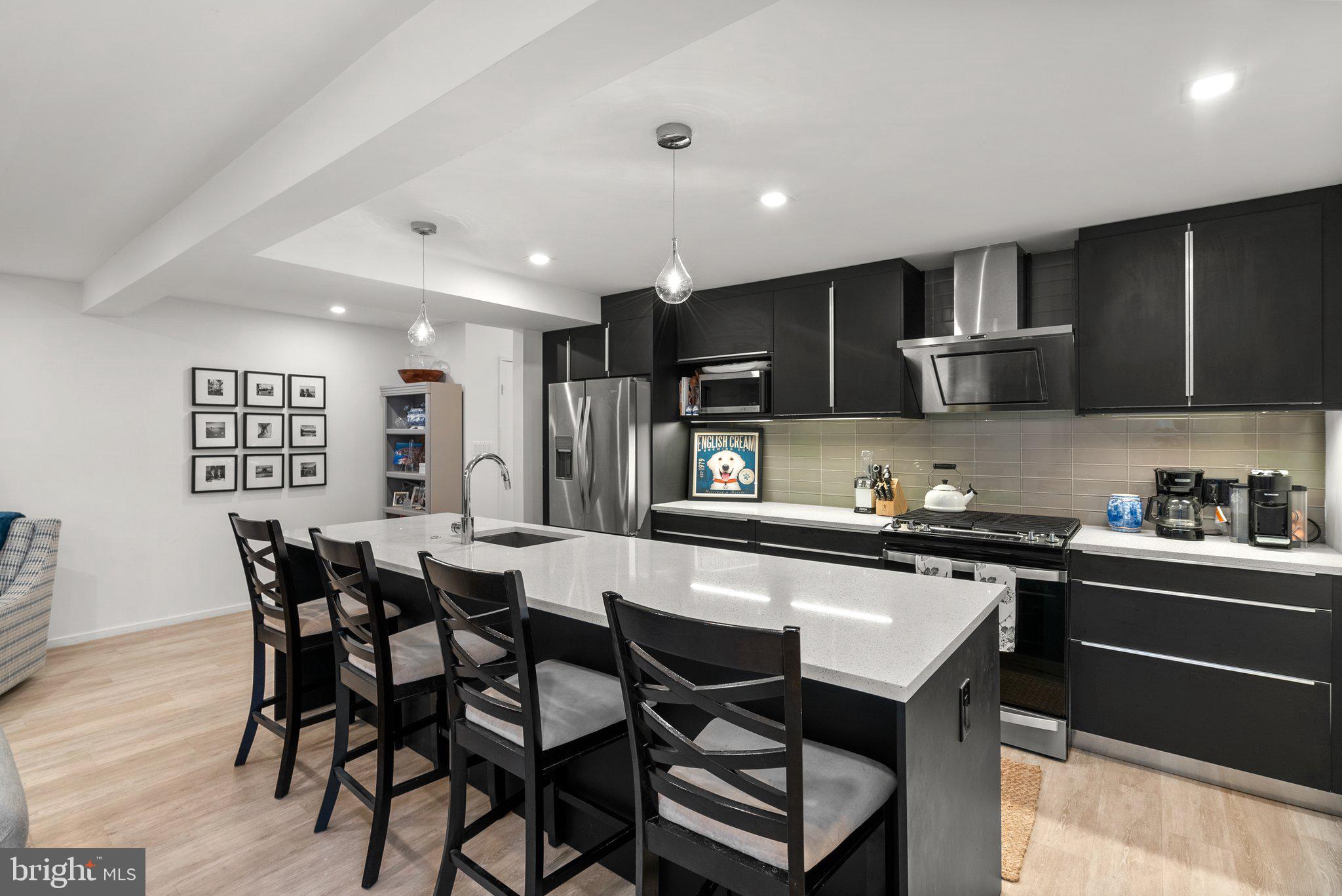 2815 39th Street Northwest Washington, DC 20007 - Photo 47 of 64 a kitchen with stainless steel appliances kitchen island granite countertop a dining table chairs and a refrigerator