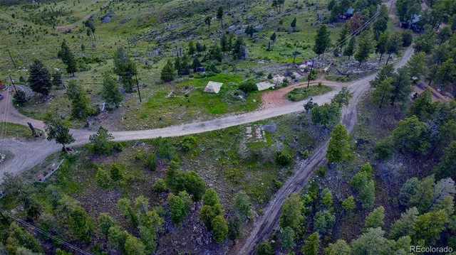 an aerial view of residential house with outdoor space and trees all around