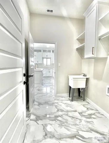 a large kitchen with kitchen island a sink stainless steel appliances and cabinets