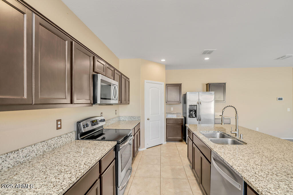 28414 Cinnabar Road San Tan Valley, AZ 85143 - Photo 12 of 32 a kitchen with stainless steel appliances granite countertop a sink stove and refrigerator