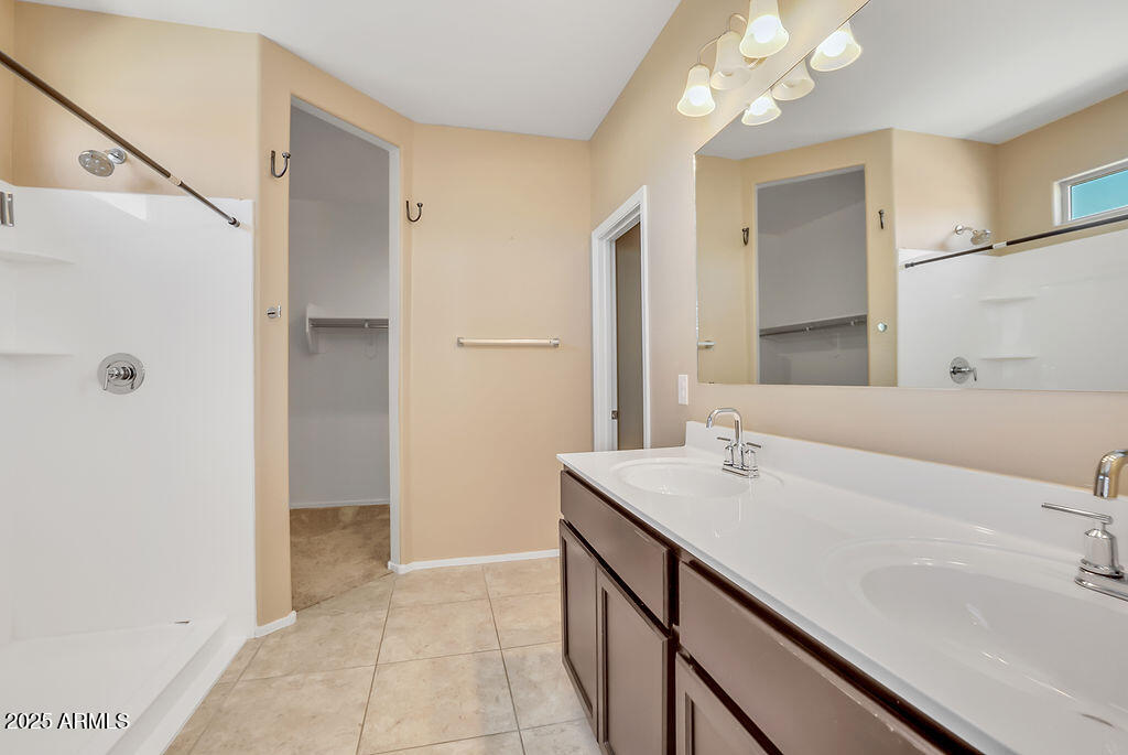 28414 Cinnabar Road San Tan Valley, AZ 85143 - Photo 23 of 32 a bathroom with a sink a vanity and a mirror