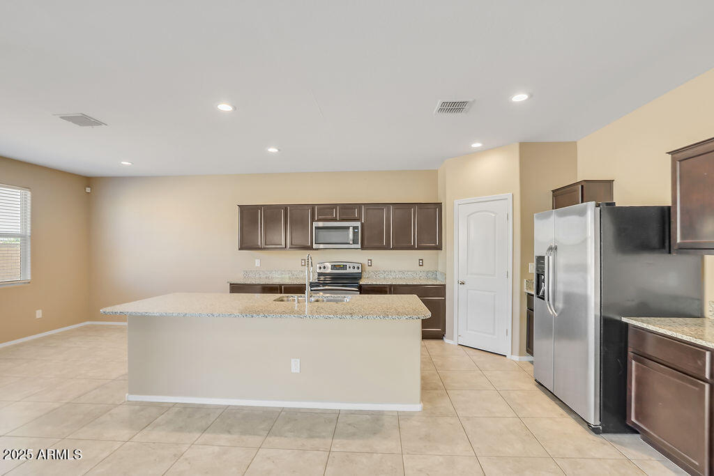 28414 Cinnabar Road San Tan Valley, AZ 85143 - Photo 9 of 32 a kitchen with stainless steel appliances a refrigerator sink and cabinets