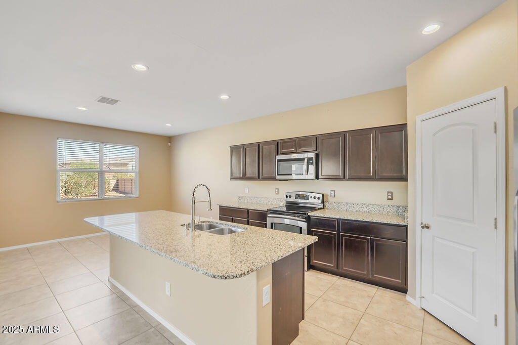 28414 Cinnabar Road San Tan Valley, AZ 85143 - Photo 10 of 32 a kitchen with stainless steel appliances granite countertop a sink and a stove top oven