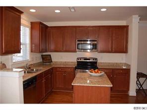 519 Jetton Street Davidson, NC 28036 - Photo 6 of 13 a kitchen with a sink a stove a microwave and wooden cabinets