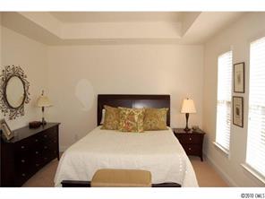 519 Jetton Street Davidson, NC 28036 - Photo 9 of 13 a bedroom with a bed and wooden floor