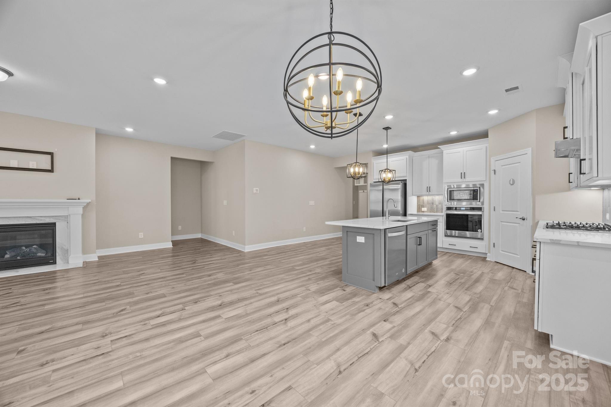 5240 Birchhill Road Mint Hill, NC 28227 - Photo 36 of 48 a large kitchen with stainless steel appliances a large counter top and wooden floors